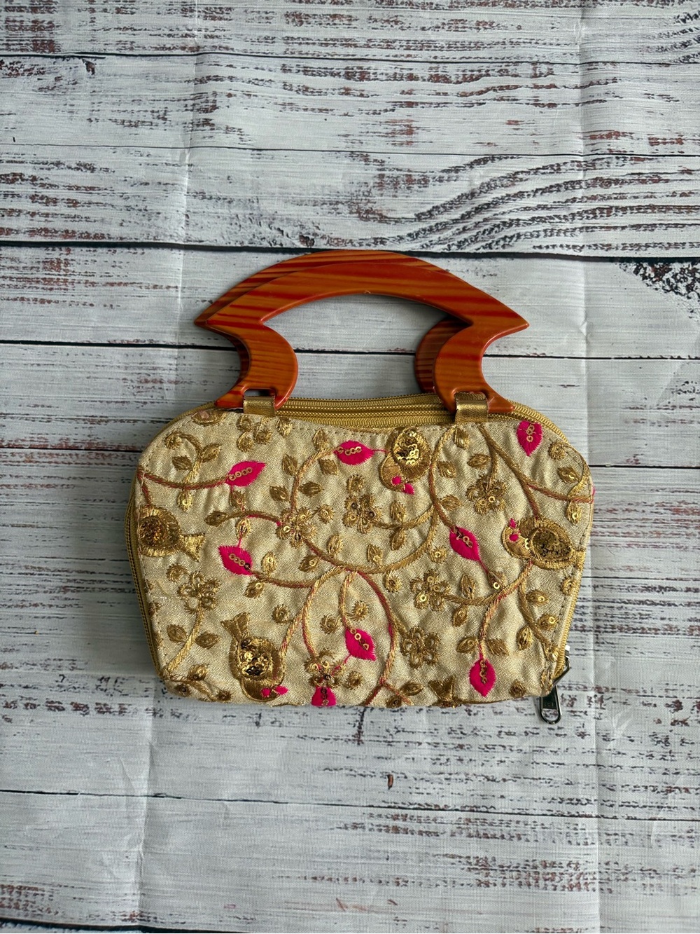 Floral embroidered, embellished handbag with wood-look bangle handle.